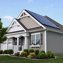 Corner shot of house with solar panels on roof and tan siding