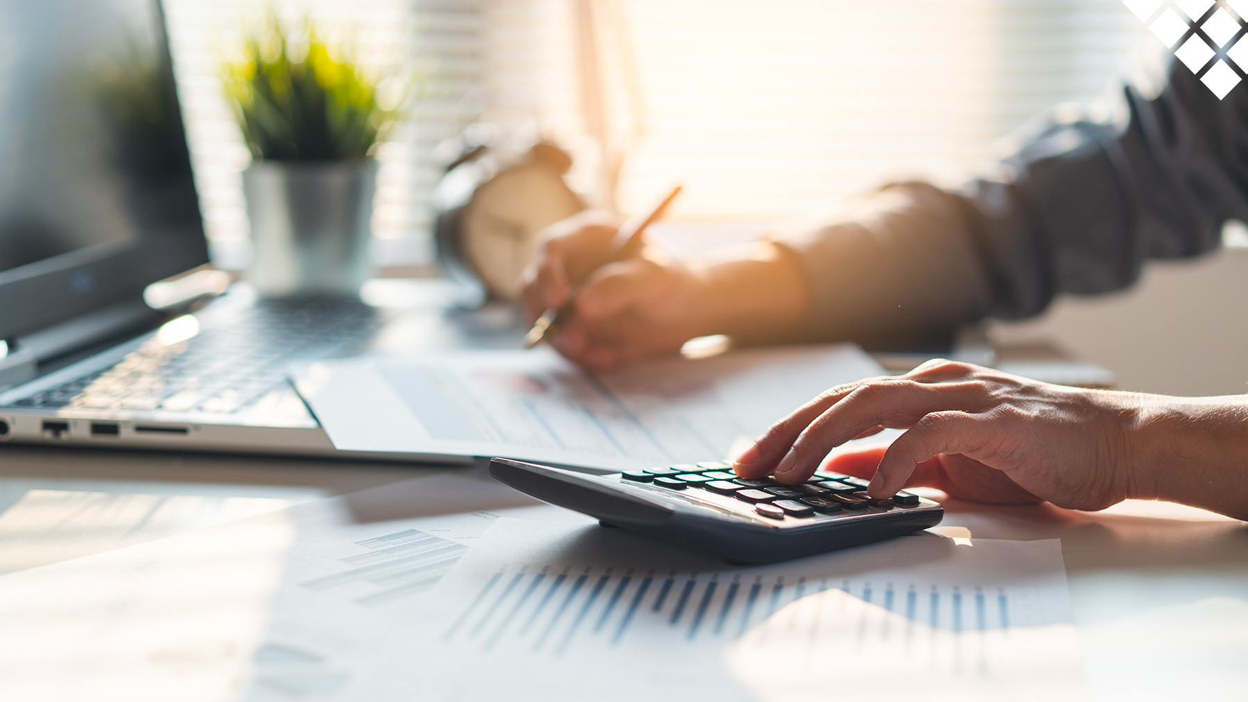 Guy using calculator to analyze budget on office desk