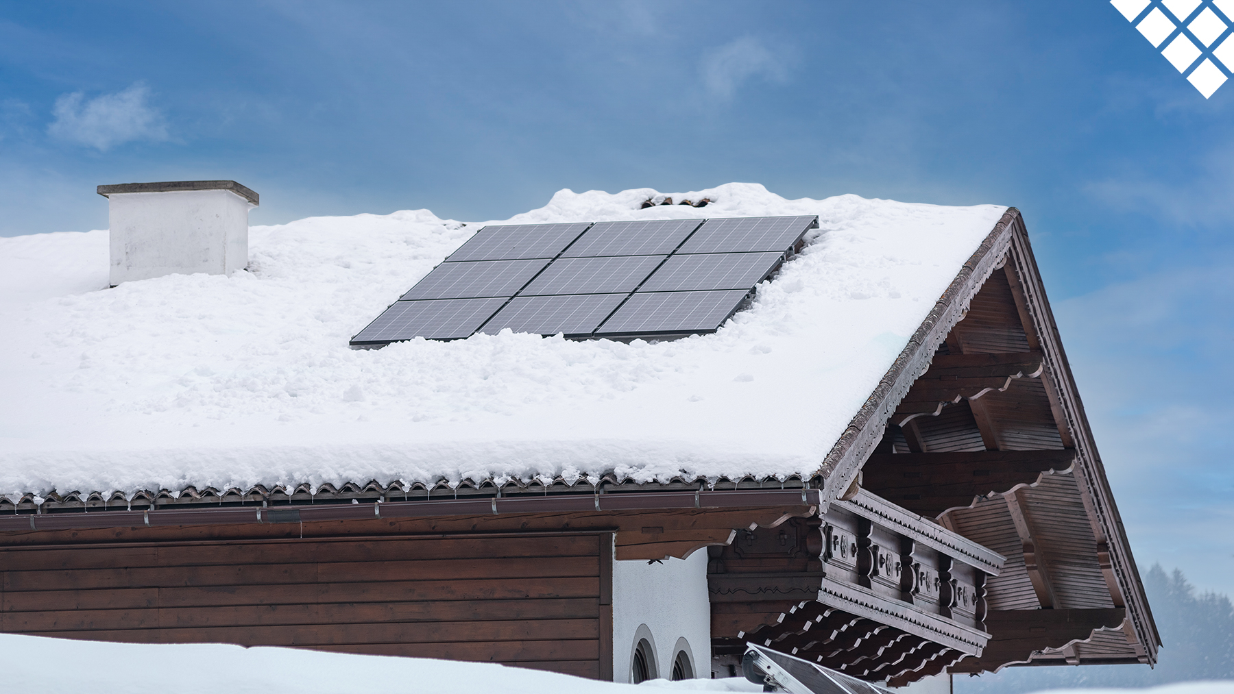 House with snow on roof and solar panels