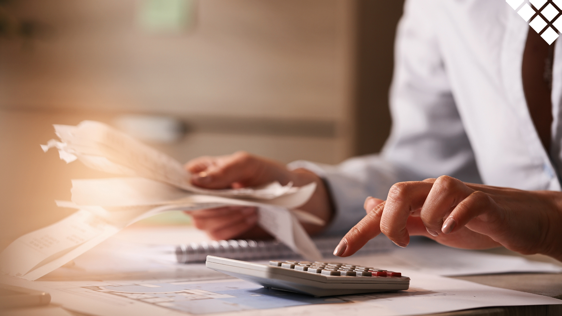 Woman calculating finances while holding a hand full of receipts