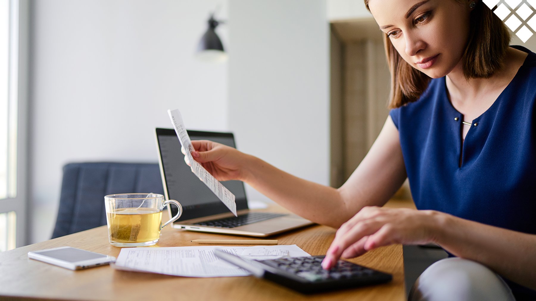 Young woman calculating utility bills with laptop, bill and calculator